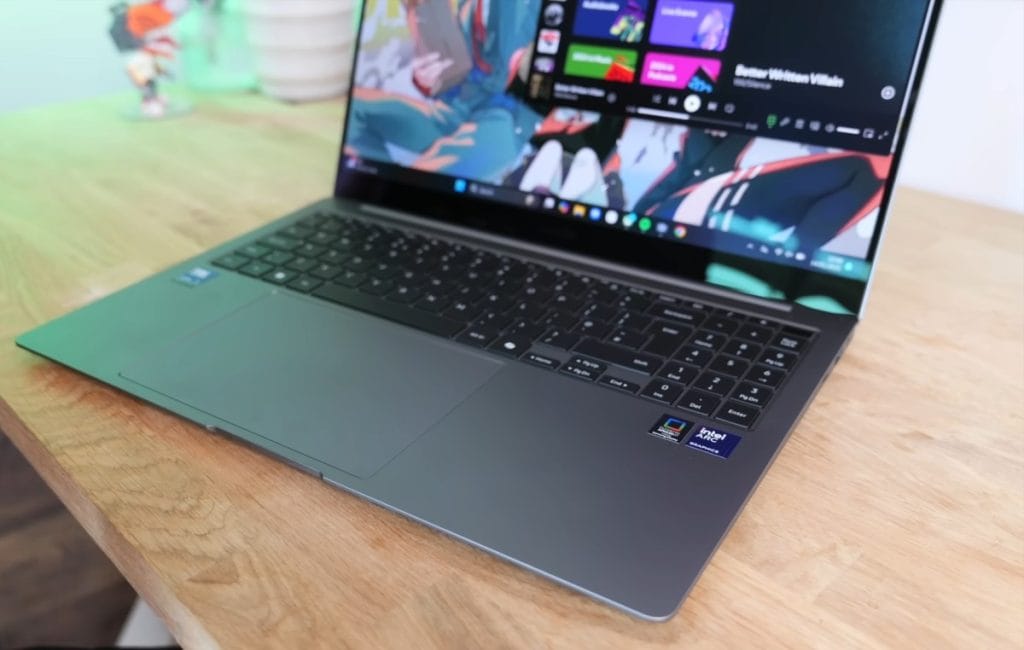 A modern Samsung Galaxy Book 5 Pro laptop with a keyboard and touchpad on a wooden table.